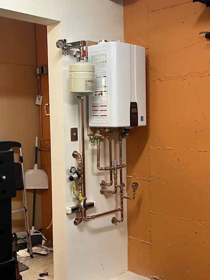 Plumbing technician inspecting water heater connections in Farmers Loop